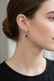 Woman wearing petite dark opaque amethyst lever back earrings with clean bezel
