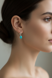 Woman wearing petite turquoise earrings with clean simple bezel